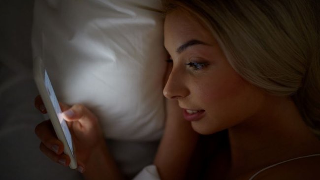 Można czytać na smartfonie przed pójściem spać, ale nie należy ładować telefonu komórkowego w łóżku.  (Źródło zdjęcia: Dolgachov)